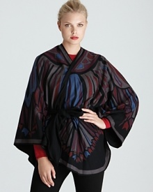 Abstract feather-like print in rich hues create an elegant poncho from Emilio Pucci.