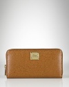 A slim and sleek zip-around wallet crafted in luxe textured leather from Lauren By Ralph Lauren.