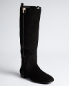 Patent insets lend a subtle sheen to Tory Burch's Erica boots, adorned with a gilded gold-tone T.