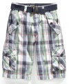 Utility with a belt. Let him keep every necessity he could possibly need with these colorful plaid cargo shorts from Guess.