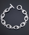 Totally trendy, this GUESS logo link bracelet goes with all of your looks. Featuring G logo links crafted in silvertone mixed metal. Approximate length: 7-1/2 inches.