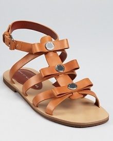 Logo-detailed and enameled discs stud leather bows on these MARC BY MARC JACOBS sandals, a fun-loving, youthful shoe with playful charm.