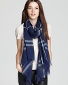 In a sheer fabrication and blue Burberry check that looks flawless with denim, this oblong scarf offers lightweight luxe.