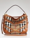 Belted details add equestrian charm to this Burberry hobo, iconic in the brand's signature check print.