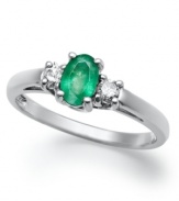 Enviable green hues. This vibrant 14k white gold ring features an oval-cut emerald (3/8 ct. t.w.) and round-cut diamond side stones (1/8 ct. t.w.).