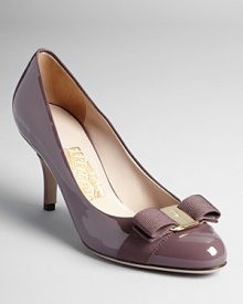 These Salvatore Ferragamo kitten heel pumps are understated yet eye-catching in pale purple patent leather with elegant gold logo bow accents.