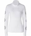 Hit the slopes in ultra chic style in Jet Sets bright white stretch ski top - Softly draped turtleneck, long sleeves with silver star circle print, raw finished seams - Form fitting - Team with matching white ski pants, aviators, and a finish of fur trimmed accessories