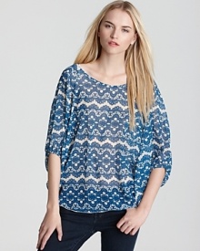 A lace print in a cool blue hue lends pattern play to a dolman sleeve top from Sweet Pea.