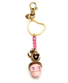 Ghoulish yet girly. Betsey Johnson adds feminine flair to this spooky skull-themed key chain. Featuring an array of decorative details--including bow and heart charms, plus flower accents and chain link embellishment--it's crafted in antique gold tone and brass tone mixed metal. Comes with a gift box. Approximate length: 6-1/4 inches.