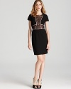 Sheer lace details lend allure to BCBGMAXAZRIA's little black sheath dress.