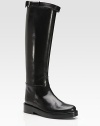 Pure equestrian elegance-- glossy leather silhouette with a convenient back zipper and adjustable buckle strap. Stacked heel, 1 (25mm) Covered platform, ¼ (5mm) Compares to a ¾ heel (20mm) Shaft, 17 Leg circumference, 14 Leather upper Leather lining and sole Padded insole Made in ItalyOUR FIT MODEL RECOMMENDS ordering one half size up as this style runs small. 