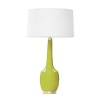 Long and lean, this lamp features a round base and polished brass accents.