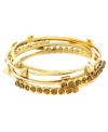 Wear 'em solo, or stack 'em five high. Vince Camuto's versatile bracelet set features five bangles in gold-plated mixed metal with topaz-colored glass accents and edgy pyramid studs. Approximate diameter: 2-1/2 inches.