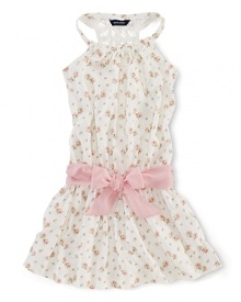 A summer charmer, this floral sleeveless dress finished with a crocheted racerback and a pretty pink sash is the perfect party dress for a June wedding.