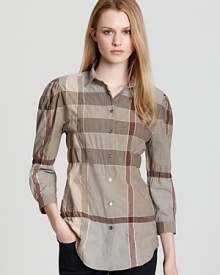 An elasticized waist and an A-line silhouette lend feminine spirit to the classic Burberry Brit check shirt. Style with dark denim and sleek flats for effortless polish.