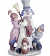 Lladro captures the magical moment as a boy and girl bring to life a snowman they just made, while their dog looks on in amazement. Handcrafted in Spain.