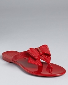 A dramatic, textured bow rests at the front of a dressed-up flip flop sandal from Salvatore Ferragamo.