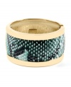 Slip on serpentine style for a fierce, overall effect. Haskell's chic cuff bracelet features a gold tone mixed metal setting that highlights a strip of teal snake print. Hinged design slips easily over the wrist. Approximate length: 8 inches.