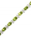 Inspired by spring. This light and airy tennis bracelet features gleaming oval-cut peridot (14 ct. t.w.) alongside diamond-accented links. Crafted in sterling silver. Approximate length: 7 inches.