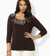 A sleek jersey top is given a feminine feel with charmeuse ruffles at the scoop neckline.