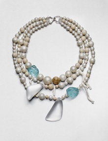 From the Lucite Wanderlust Collection. There are lots to look at in this multi-media design, offering an eclectic mix of shell pearls and richly mottled Petoskey fossil stones with hand-painted, hand-sculpted Lucite shapes, chunks of tinted glass and delicate tendrils of white coral for a head-turning effect.Shell pearlsPetoskey fossil stonesGlassWhite coralLuciteSilk ribbonLength, about 18Hook closeImported