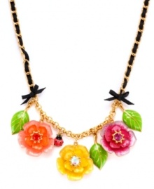 Garden variety. A trio of beautiful blooms adorns this sweet statement necklace from Betsey Johnson. Embellished with sparkling crystals, bows, leaves, an intertwined grosgrain ribbon and a charming ladybug, it's made in antique gold tone mixed metal. Approximate length: 16 inches + 3-inch extender.