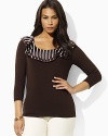 A sleek jersey top is given a feminine feel with charmeuse ruffles at the scoop neckline.