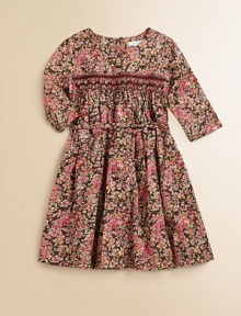 Blooming with brilliant flowers, this sweet cotton frock features a smocked bodice and and cinched waist with ribbon tie.Round necklineLong sleevesBack buttonsSmocked, gathered bodiceWaistband with ribbon tieFull, gathered skirtCottonMachine washImported Please note: Number of buttons may vary depending on size ordered. 