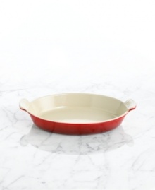 Capture the excellence of French cuisine with a refined dish that features a flat, shallow design and classic scalloped handles. Constructed of cast iron, this piece conducts and retains heat for a savory dish every time. 5-year limited warranty.