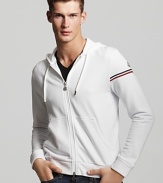 Casual gets a luxe touch with this white track hoodie from Moncler.