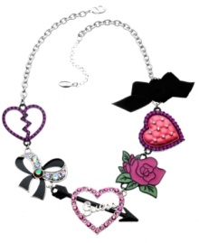 Wear your heart on your sleeve in GUESS's statement-making necklace. Crafted in silver tone mixed metal and accented with sparkling crystals, this trend-setting necklace features a multitude of charms including a broken heart, a black epoxy ribbon, the signature logo, a rose, a pink epoxy heart and a black ribbon. Approximate length: 18 inches + 2-inch extender. Approximate drop: 1-1/2 inches.