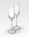 A pair of delicate, elegant and very festive flutes are made for special occasions in clear crystal with faceted crystal stems that adds an element of romance to any evening. Each, 10H X 2¾ diam. Hand wash Made in Austria