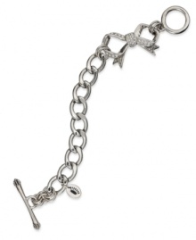 Juicy Couture's darling toggle bracelet shines with pave stones and adorable bow charms. Chain crafted in stainless steel. Charms and closure crafted in silver tone brass. Approximate length: 7-1/2 inches. Approximate drop: 1-1/2 inches.