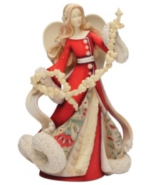 Spread joy throughout your home with this beautifully detailed angel figurine. With a floral design upon her robe, a sweet garland of hearts and snowflakes and crystal accents, she's sure to light up your holiday season.