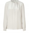 Create an elegant and polished look at the office and beyond with this silk blouse in grey-beige - Small, rounded neckline, button half-placket and subtle decorative ruffles at collar - Long sleeves feature buttoned cuffs - Loose, straight silhouette - Dress up skinny jeans or wear with a pencil skirt or under a suit