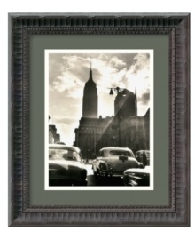 Sunlight streams through a cloudy sky to illuminate 42nd Street and the iconic Empire State Building in this classic black-and-white photo print of New York City by Mario de Biasi. Fluted detail gives the black wood frame an air of distinction.