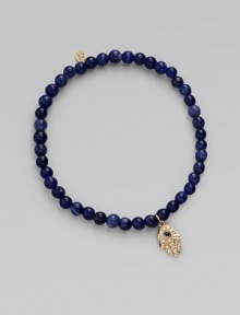 The open hand or hamsa, a symbol of protection to many cultures, is depicted in diamonds set in 14k yellow gold with a sapphire center, and hangs on a strand of deeply hued sodalite beads. Diamonds, 0.04 tcw Sapphire Sodalite 14k yellow gold Diameter, about 2 Charm length, about ½ Stretch cord Imported