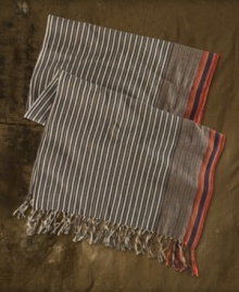 This woven cotton scarf takes a cue from rustic tribal designs with richly hued stripes and bold fringe accents.