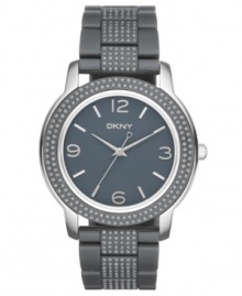 Smoky cool in a structured silhouette, by DKNY. Watch crafted of dark gray plastic and stainless steel bracelet and oval case. Embellished with 148 smoke crystal accents at bracelet, case and bezel. Dark gray dial features silver tone numerals at three, six, nine and twelve o'clock, applied stick indices, silver tone three hands and logo at twelve o'clock. Quartz movement. Water resistant to 50 meters. Two-year warranty.