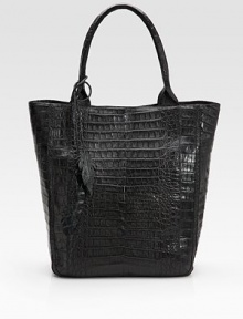 Luxurious croc-skin crafted in a roomy carryall and finished with leaf cut-out tassels.Double top handles, 8 drop Magnetic closure One inside zip pocket One cell phone pocket Suede lining 12W X 14½H X 5½D Imported