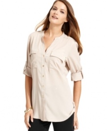 Calvin Klein's blouse features a feminine fit and buttoned roll tabs at the sleeves and sides of the hem.