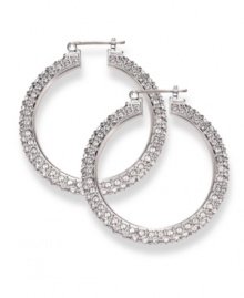 Often casually chic in nature, traditional hoop earrings get a glamorous upgrade courtesy of Swarovski. Embellished with dazzling crystals throughout, they're set in silver tone mixed metal. Approximate diameter: 1-9/16 inches.