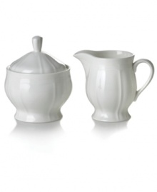 Sweeten any meal with this gracefully shaped sugar and creamer set. The soft geometric feel and clean, embossed design make it an essential part of the Antique White dinnerware and dishes collection from Mikasa. Shown at center right.