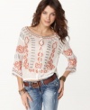 Embrace boho-chic with this embroidered peasant top from Free People. Pair it with jeans and boots for an on-trend look.