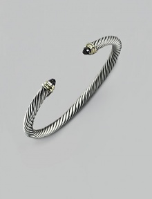 From the Cable Classic Collection. A signature Yurman cable of sterling silver, richly crowned in 14K yellow gold with black onyx end caps. Sterling silver and 14k yellow gold Black onyx Cable, 5mm Diameter, about 2½ Imported