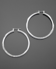 GUESS dresses up classic hoop earrings with sparkling pave crystal details. Crafted in silvertone mixed metal. Approximate diameter: 1-1/2 inches.