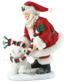 Bundle up! This adorable figurine captures Santa wrapping a polar bear in a festive colored scarf.