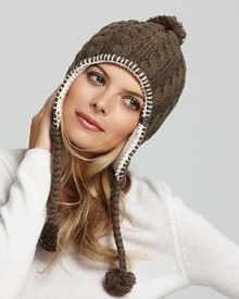 Adorable winter style starts with a cable knit beanie featuring exposed stitching and braided pom-pon ear flaps.