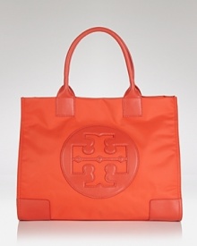 Punch up your carryall collection with Tory Burch's color-pop tote. In durable nylon and a vivid hue, the logo-stamped bag is a perfect companion for tropical getaways.