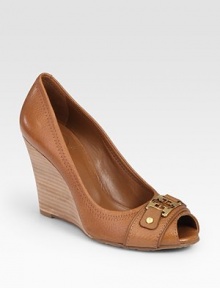 Goldtone designer emblem and a stacked wooden wedge update this leather peep toe design. Stacked wooden wedge, 4 (100mm)Leather upperLeather liningRubber solePadded insoleImportedOUR FIT MODEL RECOMMENDS ordering true size. 